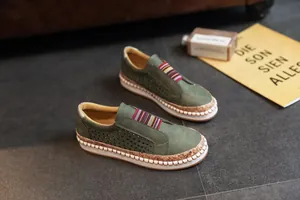 Vue détaillée de mocassins en cuir vert perforé avec semelle plateforme en liège