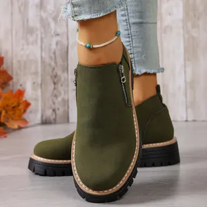 Close-up view of women's olive green suede ankle boots with side zipper and thick sole