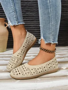 Detailansicht der beigen flachen Damenschuhe mit durchbrochenen geometrischen Mustern