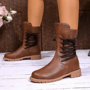 Detail view of brown mid-calf boots with side lacing and metallic stud accents