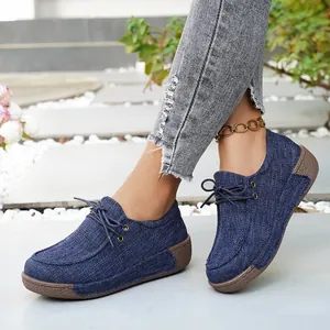 Detalle de mocasines de plataforma en denim azul marino con suelas gruesas marrones.