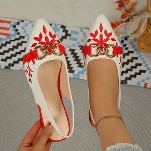 Close-up of stylish ethnic embroidered slingback sandals with pointed toe and gold chain