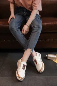 Vue détaillée de mocassins blancs perforés avec inserts élastiques colorés et semelles liège