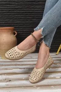 Detailansicht der beigefarbenen, durchbrochenen Sommer-Ballerinas mit Jeans kombiniert.