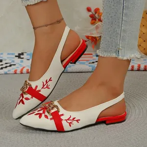 Detail shot of ethnic embroidered slingback shoes with a pointed toe and gold chain