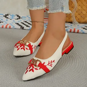 Close-up of ethnic style embroidered slingback sandals with gold chain detail