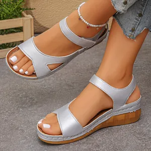 Detail view of silver wedge sandals with thick soles and adjustable velcro straps