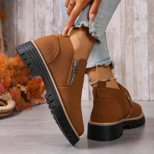 Detailed view of brown suede ankle boots with side zipper and chunky platform sole.