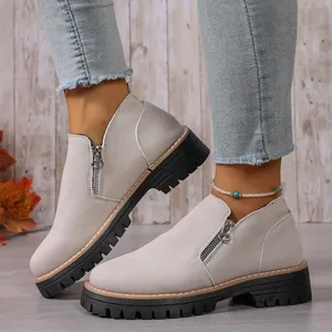 Close-up of stylish suede ankle boots featuring side zipper and thick lug soles