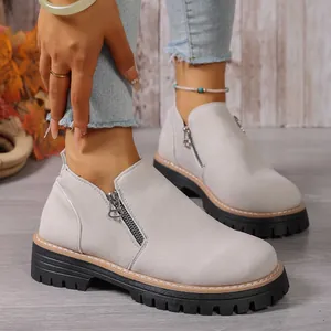 Stylish light gray suede ankle boots with side zipper and chunky treaded sole.
