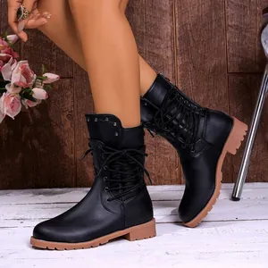Elegant black lace-up combat boots for women with studded collar and tan lug sole detail