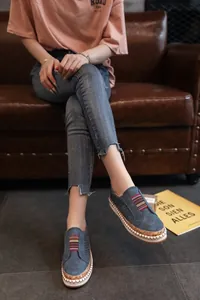 Chaussures bleues perforées décontractées portées par un mannequin sur un canapé