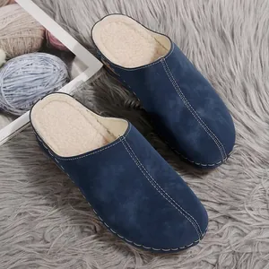 Close-up of blue fleece-lined wedge slippers with decorative white stitching