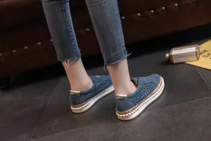 Vue de côté de mocassins décontractés bleus perforés pour femmes avec semelles blanches.