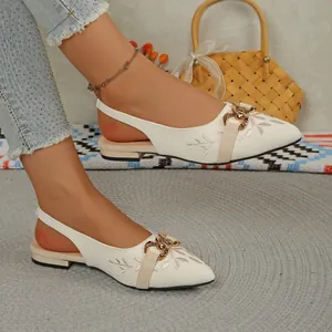Close-up of ethnic style embroidered slingback sandals with elegant gold chain decoration.