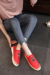Gros plan sur des chaussures rouges respirantes avec élastique rayé et semelle tissée