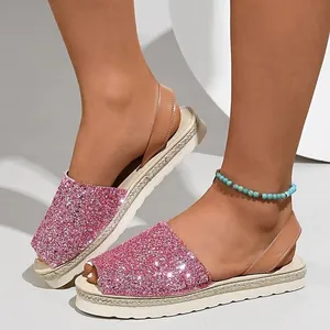 Close-up of pink glitter peep toe sandals with woven espadrille platform sole.