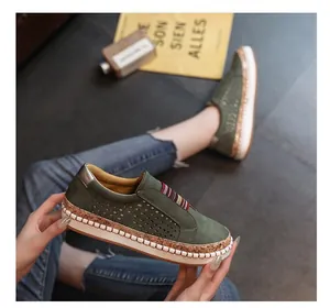 Close-up detail of green perforated platform slip-on shoes with colorful elastic