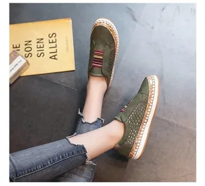 Close-up of green perforated slip-on sneakers with colorful elastic straps and platform soles.