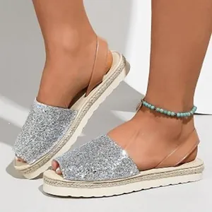 Detailed view of women's silver glitter peep-toe sandals with platform espadrille sole.