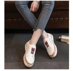 Close-up detail showing breathable perforated design and colorful elastic band on white shoes