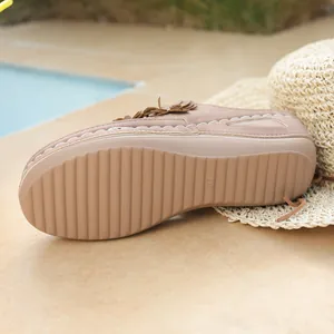 Close-up view of anti-slip wavy sole and side detail on brown wedge platform shoes.