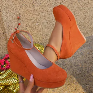 Close-up detail of stylish orange suede platform wedge heels with an adjustable ankle strap