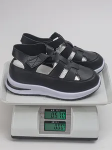 Schwarze römische Plateausandalen für Damen, auf einer Digitalwaage mit 0,57 kg