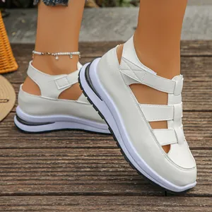 Nahaufnahme weißer römischer Plateausandalen mit Klettverschluss an einem Modell