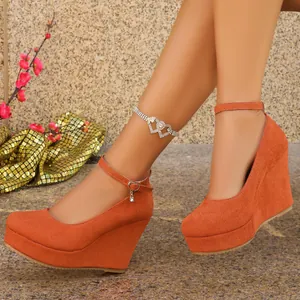Close-up of orange suede wedge heels with elegant ankle strap and platform