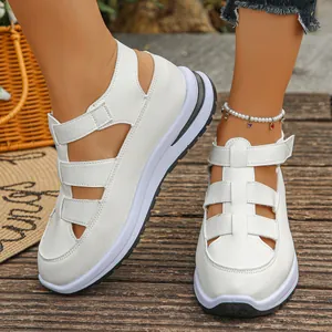 Weiße Plateau-Römersandalen mit Klettverschluss am Modell im Freien gezeigt