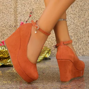 Close-up of orange suede wedge pumps with adjustable ankle straps and round toe design