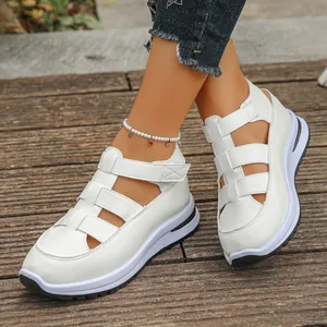 Detailansicht weißer Plateausandalen im Römer-Stil mit Klettverschluss auf Holz