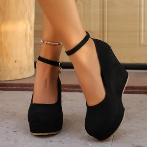 Detailed view of black suede platform wedge heels with an adjustable ankle strap.
