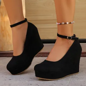 Close-up of elegant black suede wedge heels with adjustable ankle strap and platform