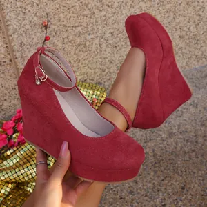 Detailed macro view of burgundy suede wedge pumps featuring high platform and ankle strap detail