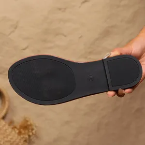 Detailopname van de duurzame antislip rubberen zool van een zomerse damesslipper