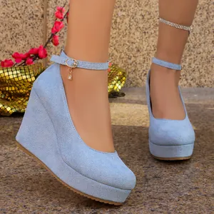 Detail shot of light blue suede wedge heels featuring an elegant ankle strap buckle.