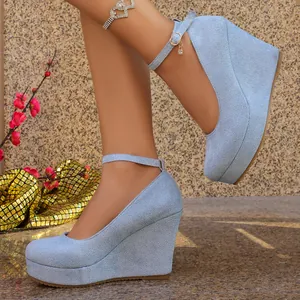 Elegant light blue suede wedge heels featuring a round toe and adjustable ankle strap