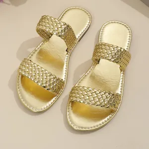 Bovenaanzicht detail van elegante goudkleurige metallic gevlochten dames slippers.