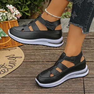 Detailansicht von schwarzen römischen Plateausandalen mit Klettverschluss im Freien.