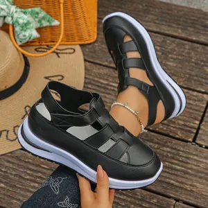 Nahaufnahme schwarzer Gladiatorensandalen mit dicker Plateausohle und Klettverschluss