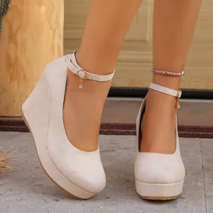 Close-up of elegant beige suede platform wedge shoes with adjustable ankle straps