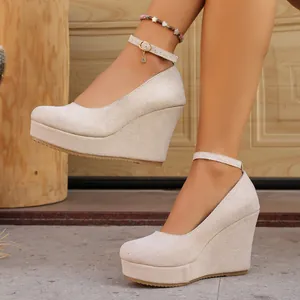 Elegant beige suede wedge heels featuring a platform sole and a delicate ankle strap detail
