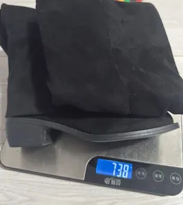 Detailed view of black suede over-the-knee boots weighing 738g on a digital scale