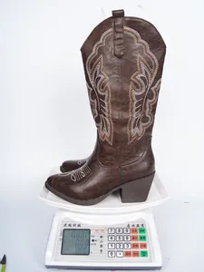 Détail montrant le poids des bottes de cow-boy marron brodées sur une balance numérique