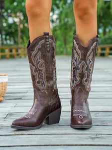Vue détaillée de la broderie florale blanche sur ces bottes de cowboy marron rétro
