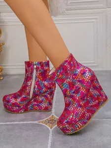 Close-up detail of colorful pebble pattern wedge boots with platform and side zipper.