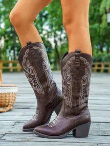 Détail de bottes de cowboy marron vintage brodées avec col en V et talons épais