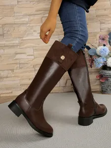 Brown leather patchwork knee-high riding boots featuring side zipper and gold floral detail